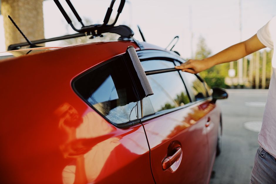 Carefully cleaning a newly installed car window to ensure perfect visibility